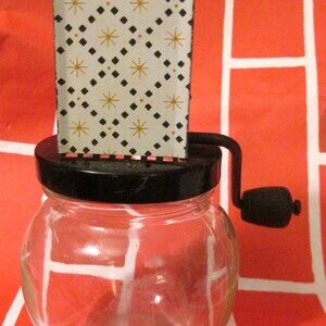 Androck Nut Grinder Black Metal with Atomic Strburst Pattern on Metal